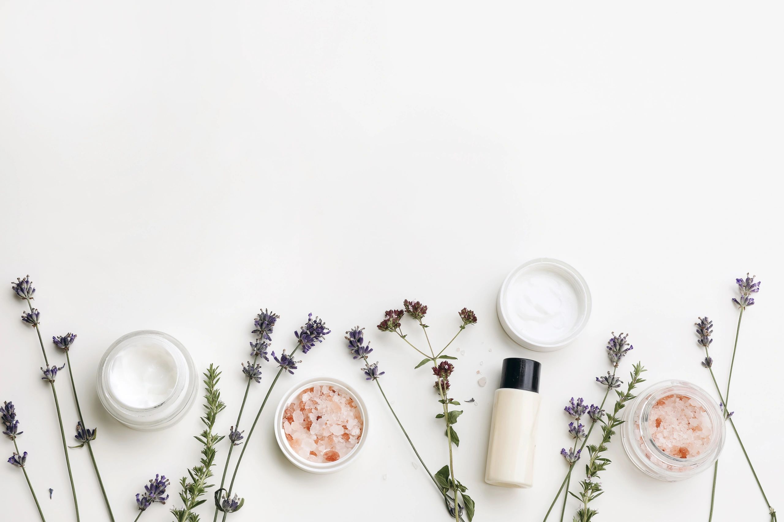 Cosméticos orgánicos en mesa blanca con hierbas