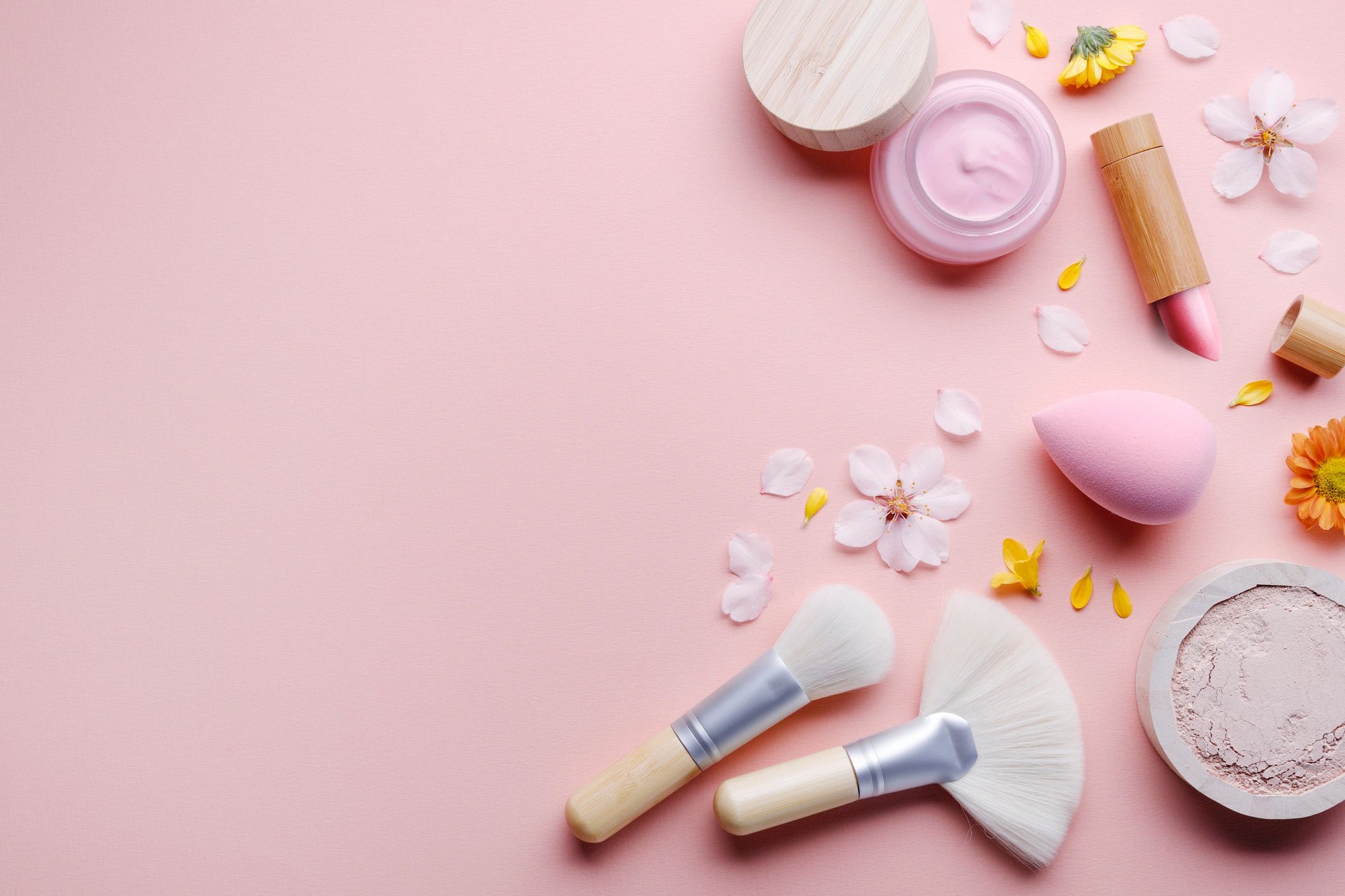 Productos de skincare sobre fondo rosa pastel