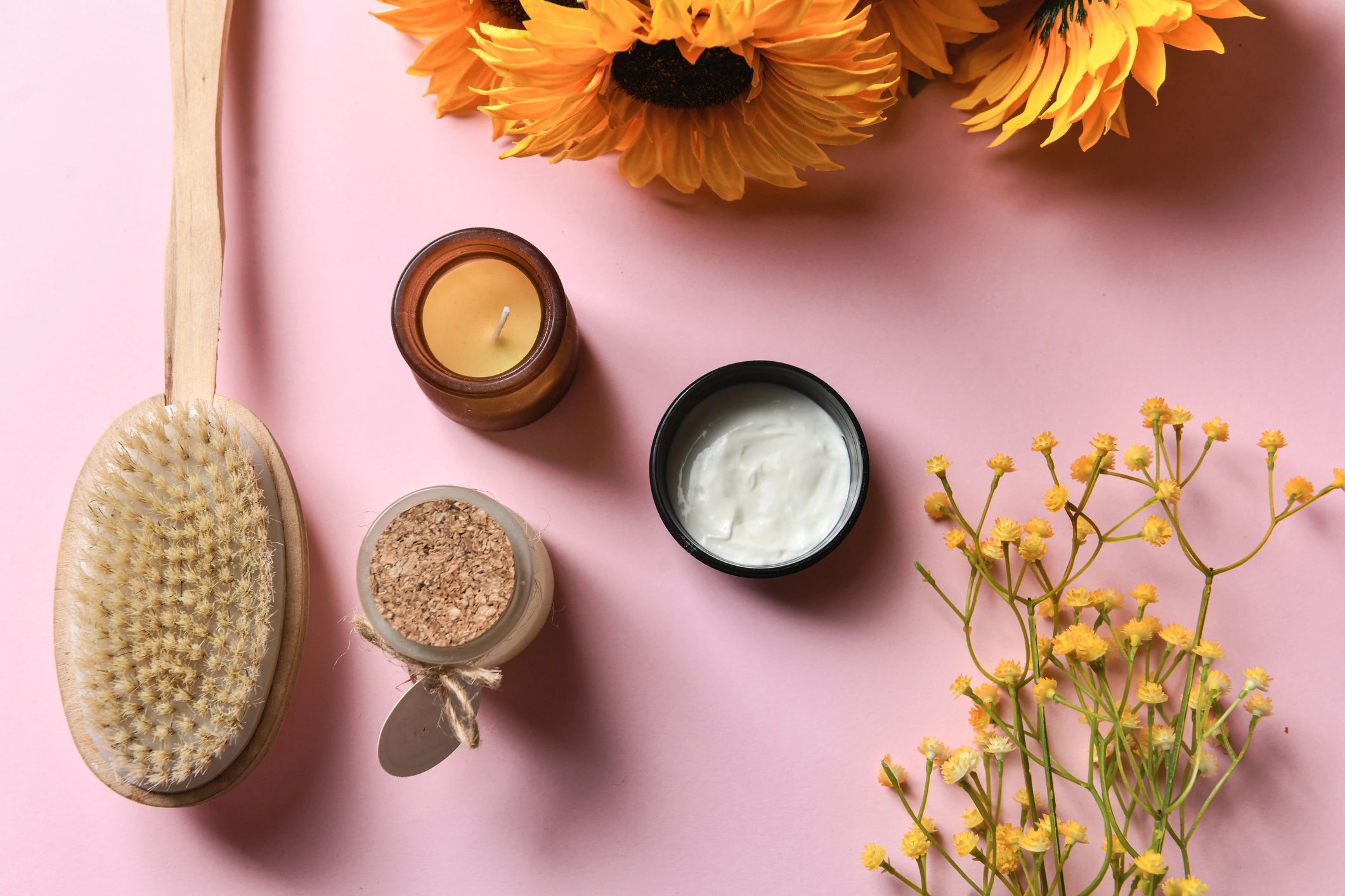 Productos de spa y cuidado corporal en fondo rosa
